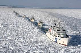 Icebreaking patrol boat leads fishing boats through drift ice