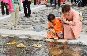 Paper-made "hina" dolls floated on river