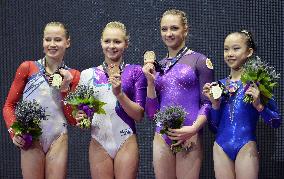4 gymnasts share uneven parallel bars gold