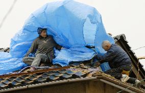 Noto earthquake - man ponders what to do with damaged house