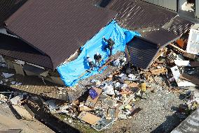 Quake-hit people clean up damaged houses