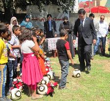 Japanese soccer official plays with Iraqi orphans with donated balls