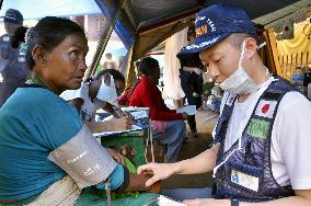 Woman has blood pressure taken by Japanese paramedic in Nepal