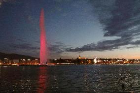 Big fountain at Lake Geneva lit up in red