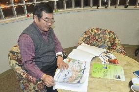 Japanese man checks Hakodate history guidebook