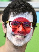 Olympic scenes: Fan paints face with Japan flag