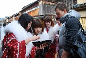 Students in kimono guide foreign tourists in Kanazawa