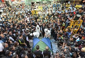 H.K. officials begin dismantling protest barricades