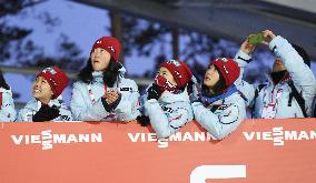 Japanese female ski jumpers cheer for Kasai in men's normal hill