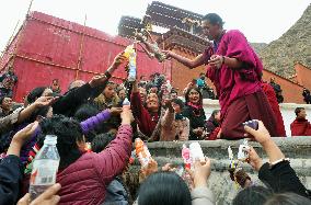 Worshippers get holy water at Tibetan Buddhist temple in China's Gansu