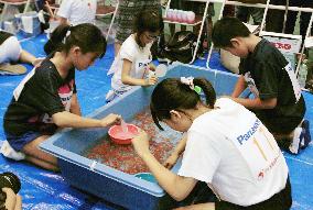 Children try to scoop up goldfish in annual competition