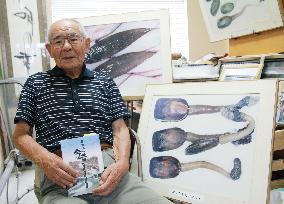 Aquarium owner poses with Ariake Sea product photos