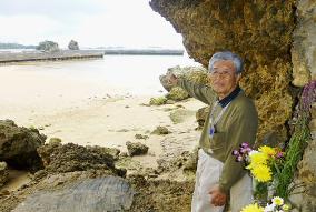 Okinawa man points from ancestors' grave to site for U.S. base relocation