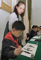 Woman teaches calligraphy at Pyongyang school