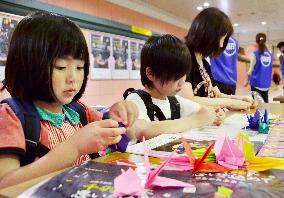 Kids make paper cranes at Osaka subway station to wish for peace