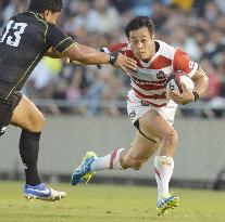 Japan wing Fukuoka tries to dodge tackle in game vs. World XV