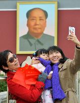 Women, girl take selfie in front of Tiananmen Gate