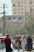 People walk under security cameras in China's Xinjiang Uyghur region