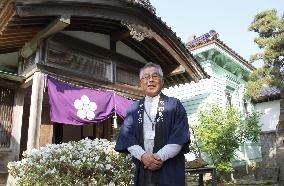 Realtor stands before repaired old mansion in Hakodate, northern Japan