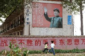 Kids run past Chinese school promoting Mao Zedong's teachings