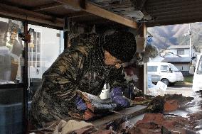 Fish shop owner in tsunami-hit town fillets salmon