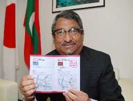 Maldivian envoy to Japan shows notebook containing stamp collection