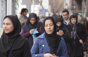 Iranian women walk with headscarves in Tehran