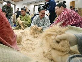 Sumo wrestlers prepare new rope for new yokozuna Kisenosato