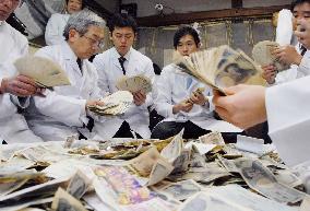Bankers collect money offered at Kyoto shrine