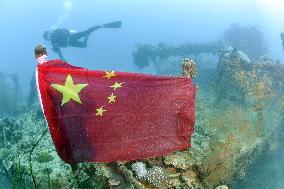 Chinese flag tied onto wreck of WWII Japanese tanker