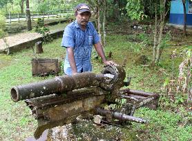 Landowner stands by wreckage of WWII cannon on Biak