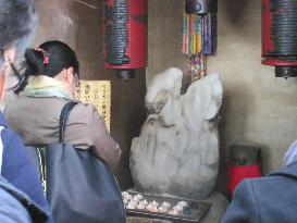 Visitors pray in Zenizuka Jizo-do at Sensoji