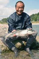 Man shows off salmon caught with net