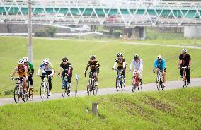 Cyclists pedal on tour along Kano River on Izu Peninsula