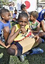 Children in Rio slum given soccer shoes from Japan