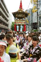 Young women help pull float before parade at Kyoto summer festa