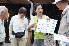 Tour guide explains harvesting of seaweed in Hokkaido to tourists