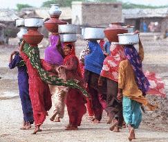 Pakistani women carrying water to their village.