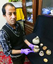 Afghan museum curator shows item stolen from Remains of Jam