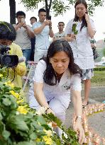 Nurse offers flowers for victims of Tianjin blast