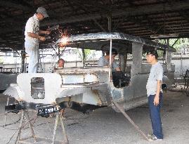Men assemble jeepney in Philippines