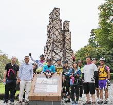 Participants in cycling tour pose before World Heritage furnace