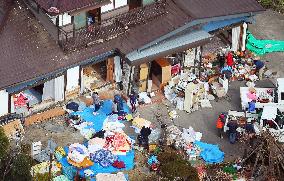 Quake-hit people clean up damaged houses