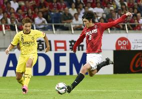 Urawa midfielder Kashiwagi tussles with Kashiwa defender Yamanaka