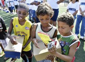 Children in Rio slum given soccer shoes from Japan