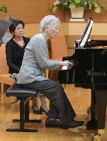 Empress plays piano at music workshop
