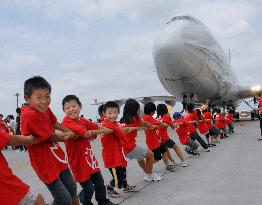 Children drag jumbo jet at Narita airport