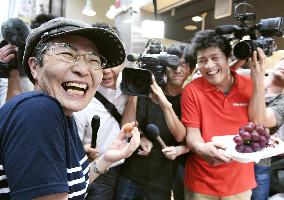 People queue for free tasting of extremely pricey grapes