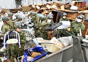 Japanese troops remove heaps of broken furniture in quake-hit area
