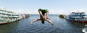 Boy jumps into river